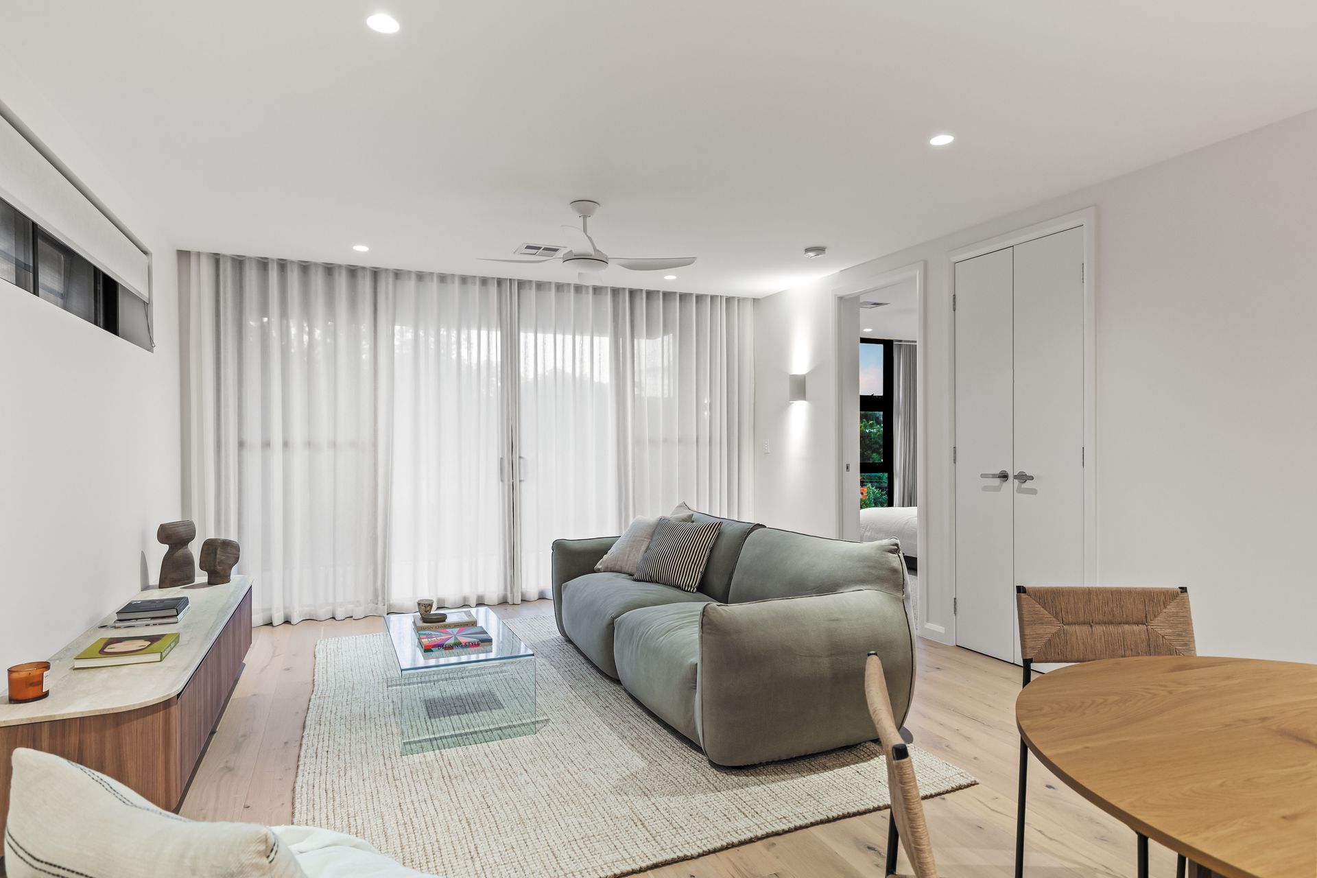Living room with green sofa and timber cabinetry